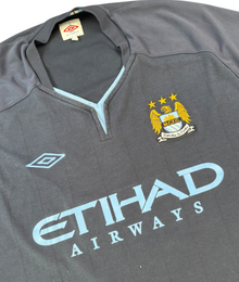 VBYC Manchester City Fußballtrikot von Umbro in Dunkelblau mit hellblauen Details und Vereinswappen auf der Brust