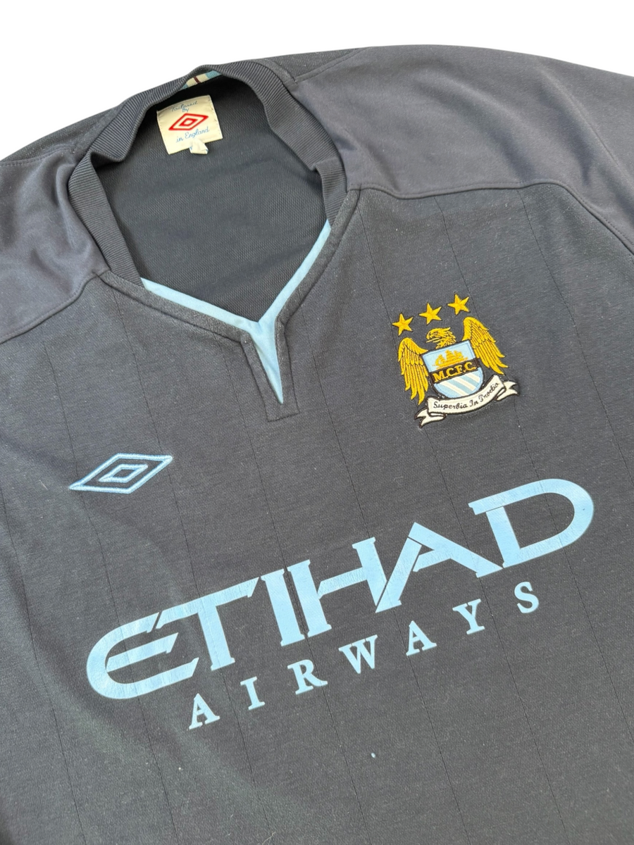 VBYC Manchester City Fußballtrikot von Umbro in Dunkelblau mit hellblauen Details und Vereinswappen auf der Brust