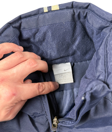 VBYC Nike Windbreaker in Dunkelblau mit Ripstop-Struktur, Stehkragen und Innenfutter, Detailansicht des Markenlabels